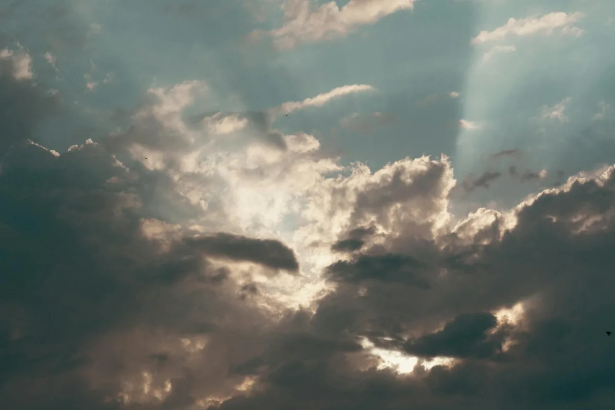 A split scene: sunny sky on the left producing visible ozone smog, overcast sky on the right with clear air.
