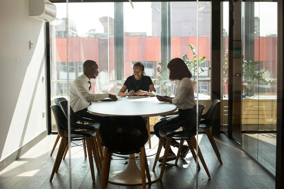 A small meeting room, sunlight through window blinds, with a faint blue overlay suggesting accumulated air.
