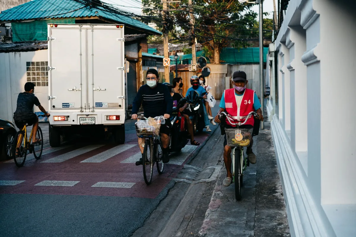 A split scene: a cyclist riding in traffic on the left, a sensor mounted on a kitchen wall on the right, with a dashed line between them.