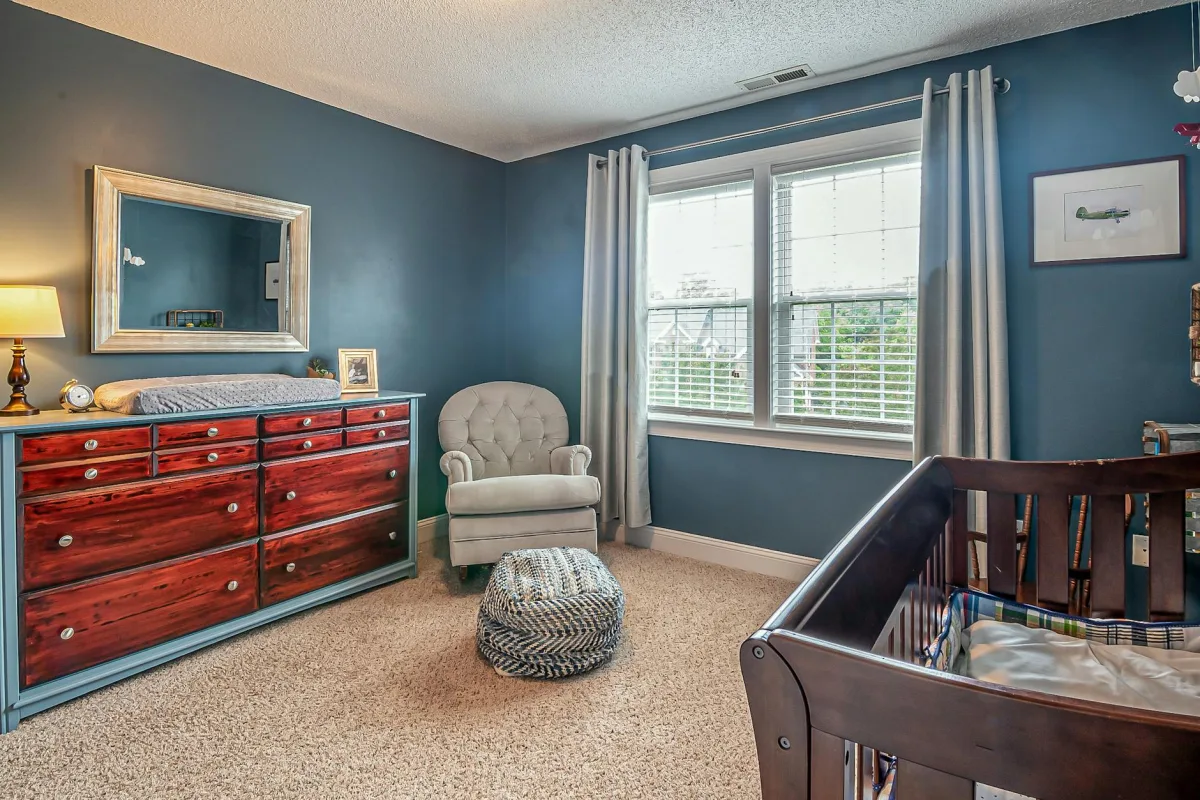 A nursery with a crib by an open window, a humidifier on a low shelf, and a Terrestream sensor mounted at crib-height on the opposite wall.