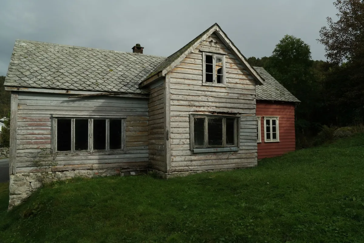 A split illustration: a tight contemporary house on the left with arrows showing zero air leakage and an HRV unit; a leaky 1925 farmhouse on the right with arrows showing infiltration through window frames, attic, and sill plate.