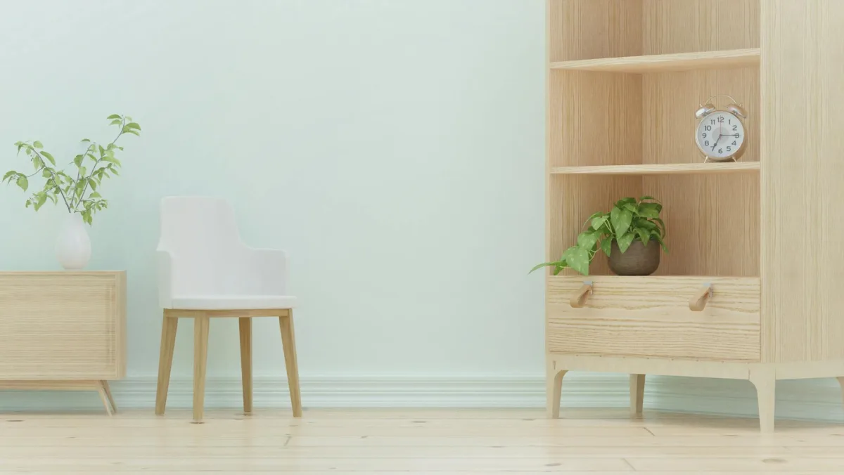 A small air-quality sensor on a wooden bookshelf in a sunlit living room.