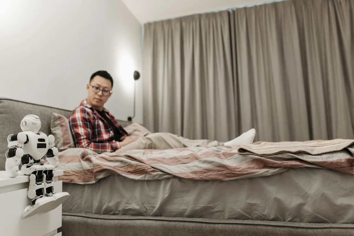 Une machine CPAP sur une table de chevet avec réservoir d'humidificateur visible, à côté d'un capteur Terrestream montrant les statistiques nocturnes de la chambre.