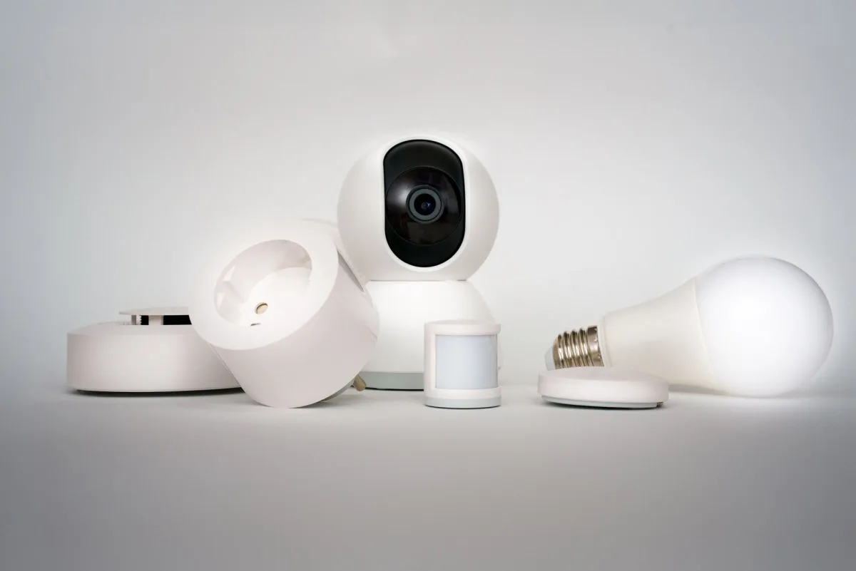 Una alarma de humo residencial montada en el techo de un pasillo, con un sensor Terrestream visible en una mesa lateral debajo.