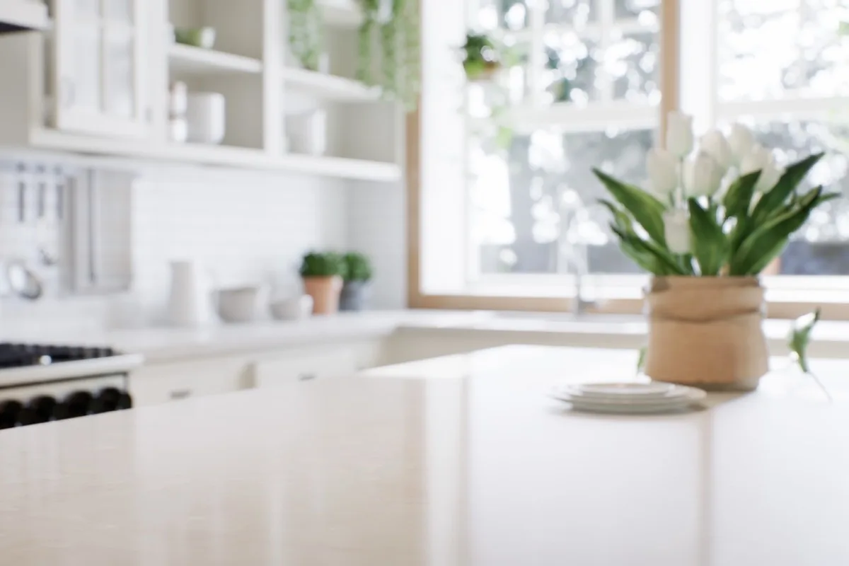 A bright, sunlit kitchen with white tulips on the counter